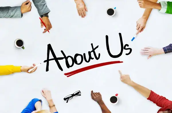 Vidari Group team collaborating around a table with 'About Us' written in the center